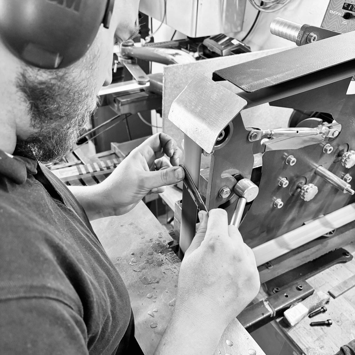 Kévin, coutelier de L’Atelier 555, travaillant une lame au backstand